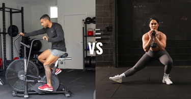 man on exercise bike and woman doing side lunge with dumbbell