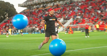 Man kicking gym ball on soccer field