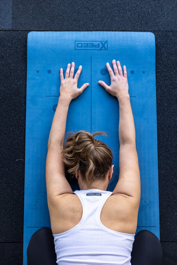 woman stretching on yoga mat 
