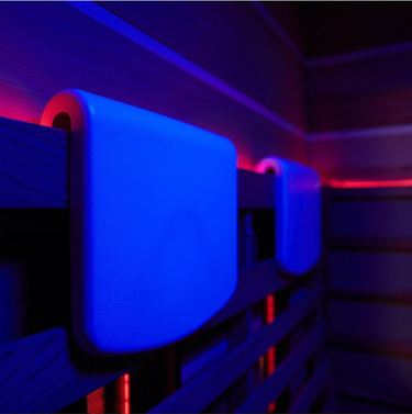 Interior close up of a sauna with head cushions and neon lighting.