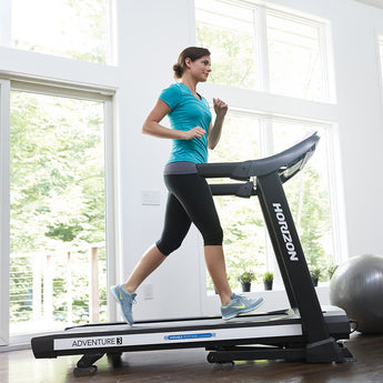 Woman running on a Horizon Adventure 3 Treadmill in her home gym